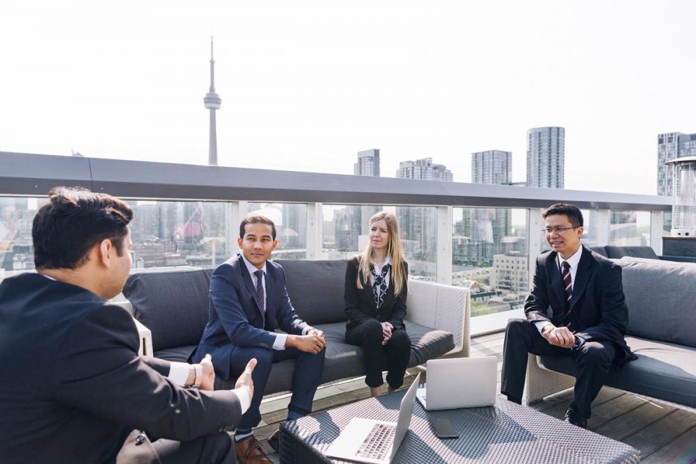 Business people conversing in front of the Toronto skyline.