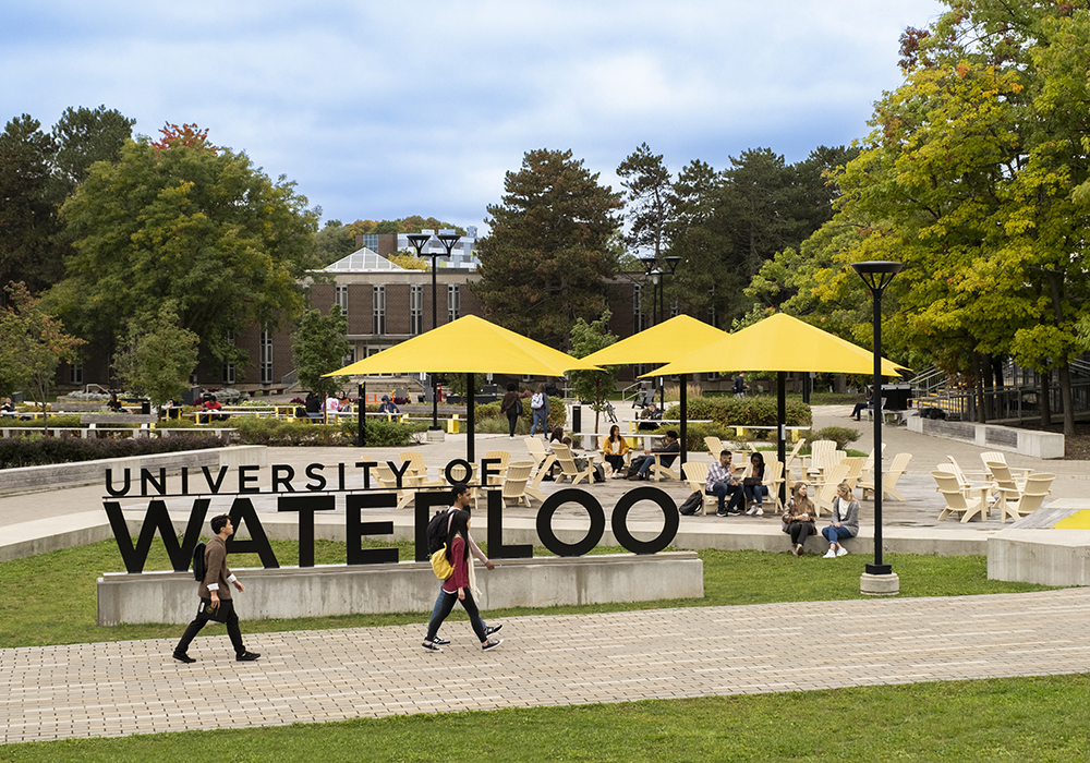 Students walking outside in the Faculty of Arts quad at the University of Waterloo campus