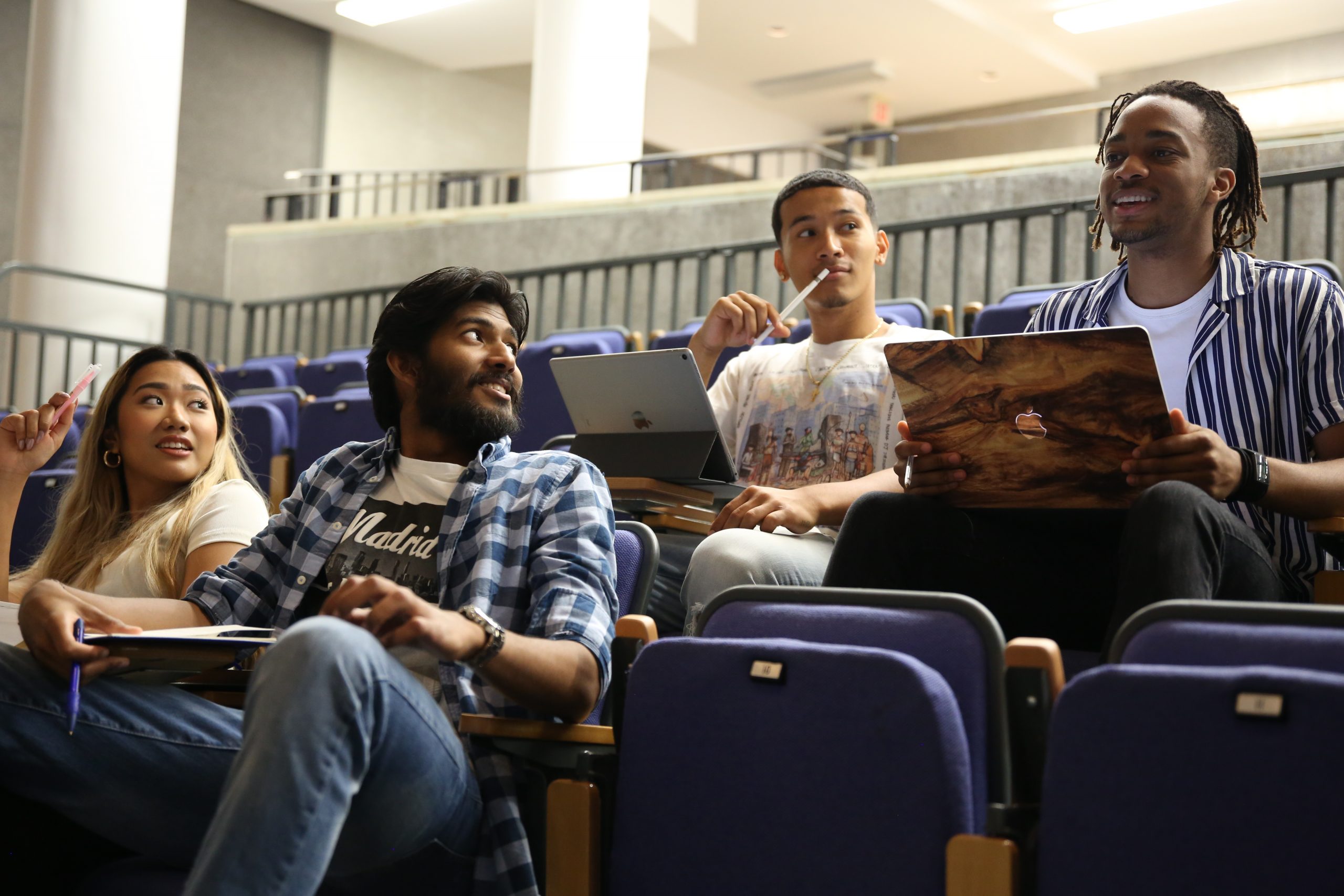 Students chatting in lecture hall.