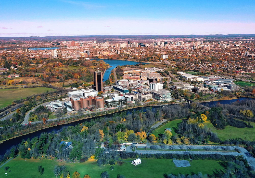 View of Carleton campus from above, from a distance - Rideau River, surrounding farmland, downtown Ottawa in the background